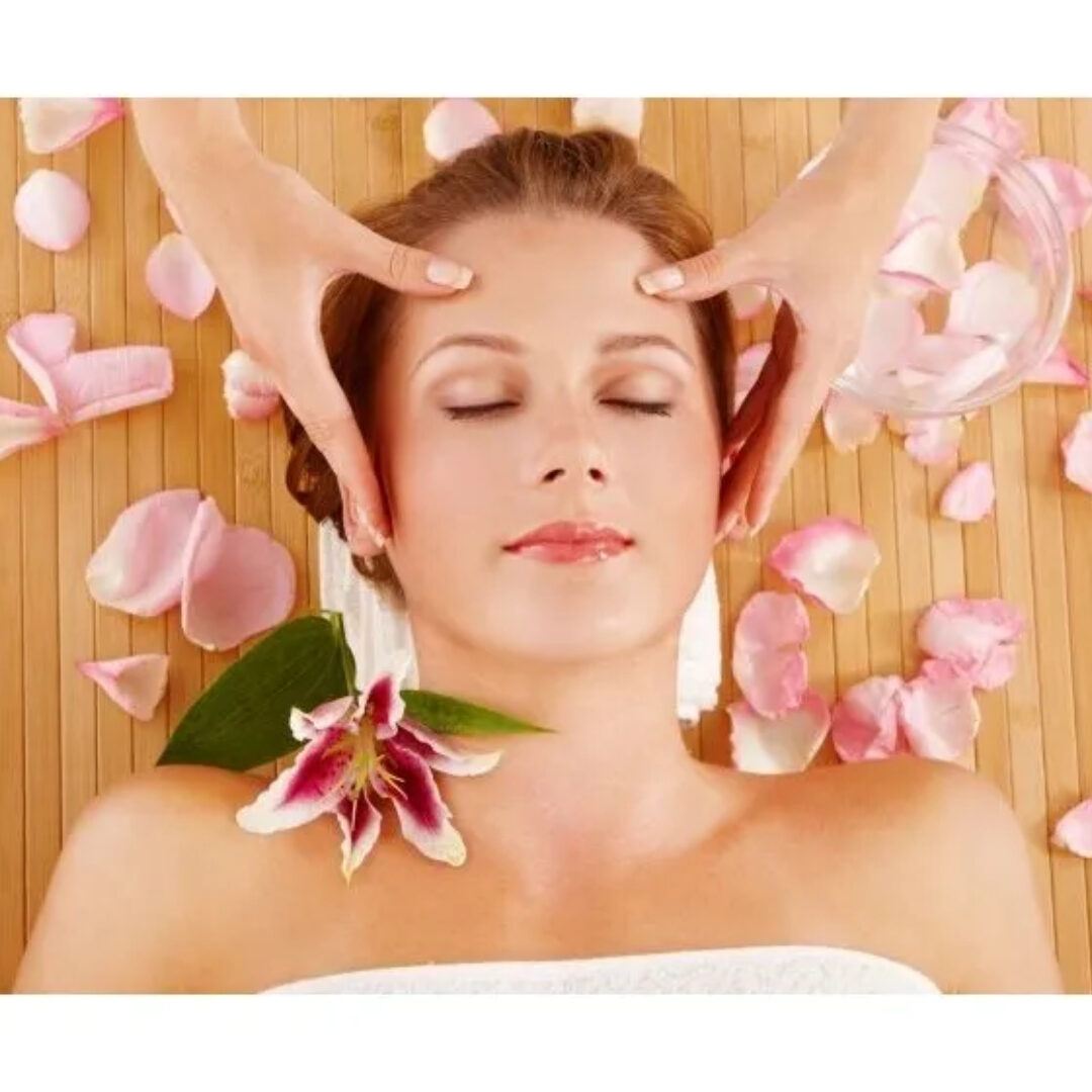 A woman getting her face washed with pink flowers.